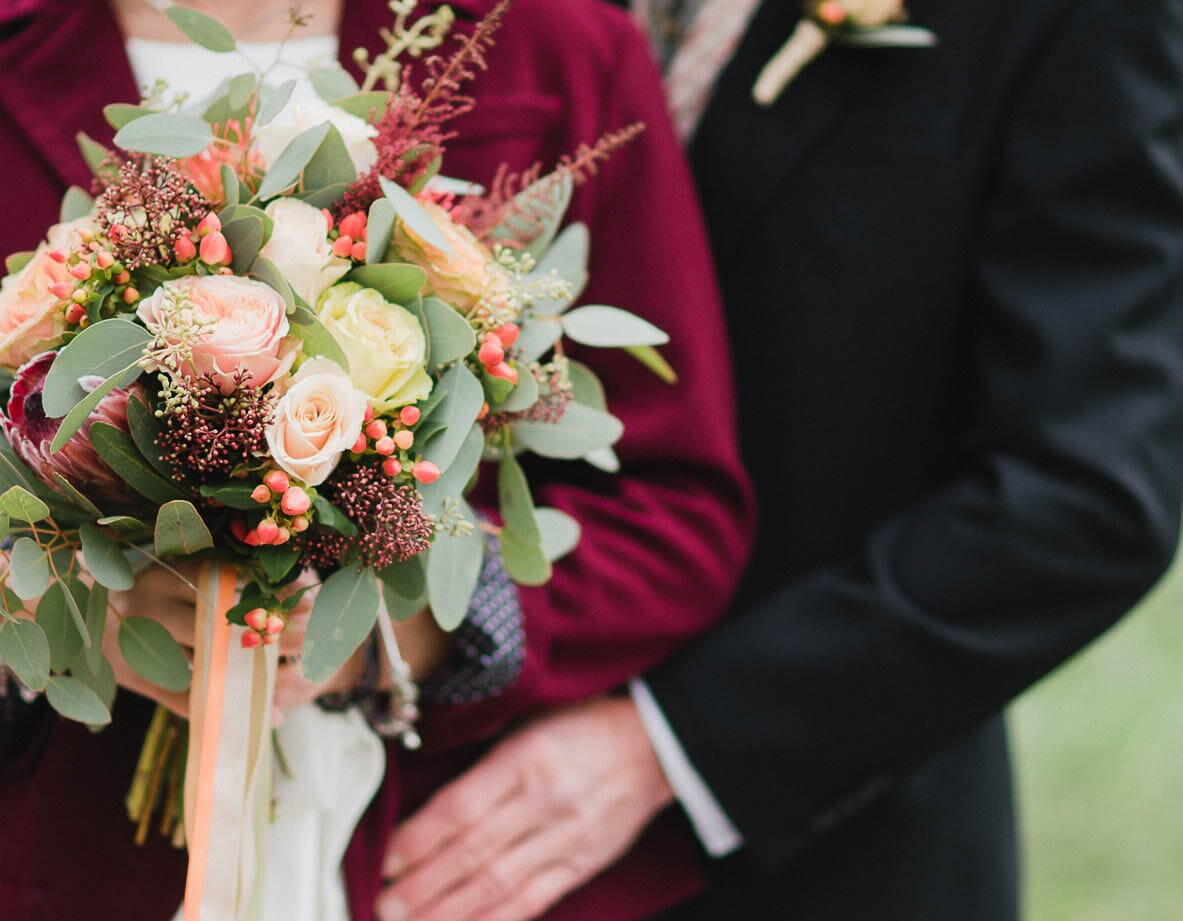 DIY wedding flowers for fall, featuring a bouquet and floral crown with coral garden roses, scabiosa pods, olive leaf, waxflower and chrysanthemums.