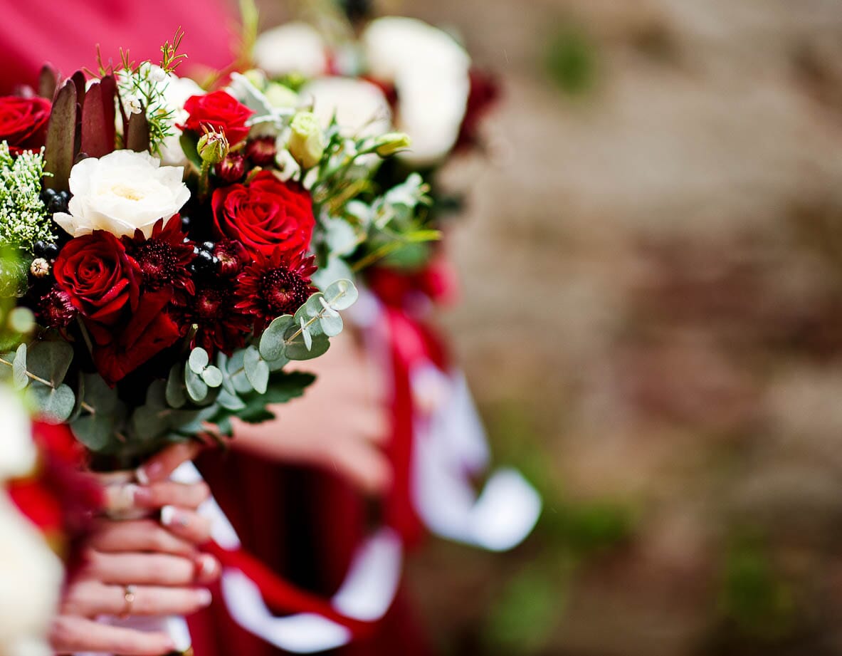 DIY bridal bouquet with red and white roses, white spray roses, and eucalyptus.