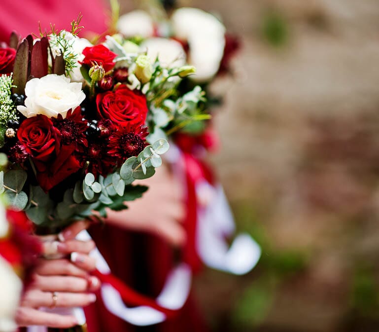 DIY bridal bouquet with red and white roses, white spray roses, and eucalyptus.