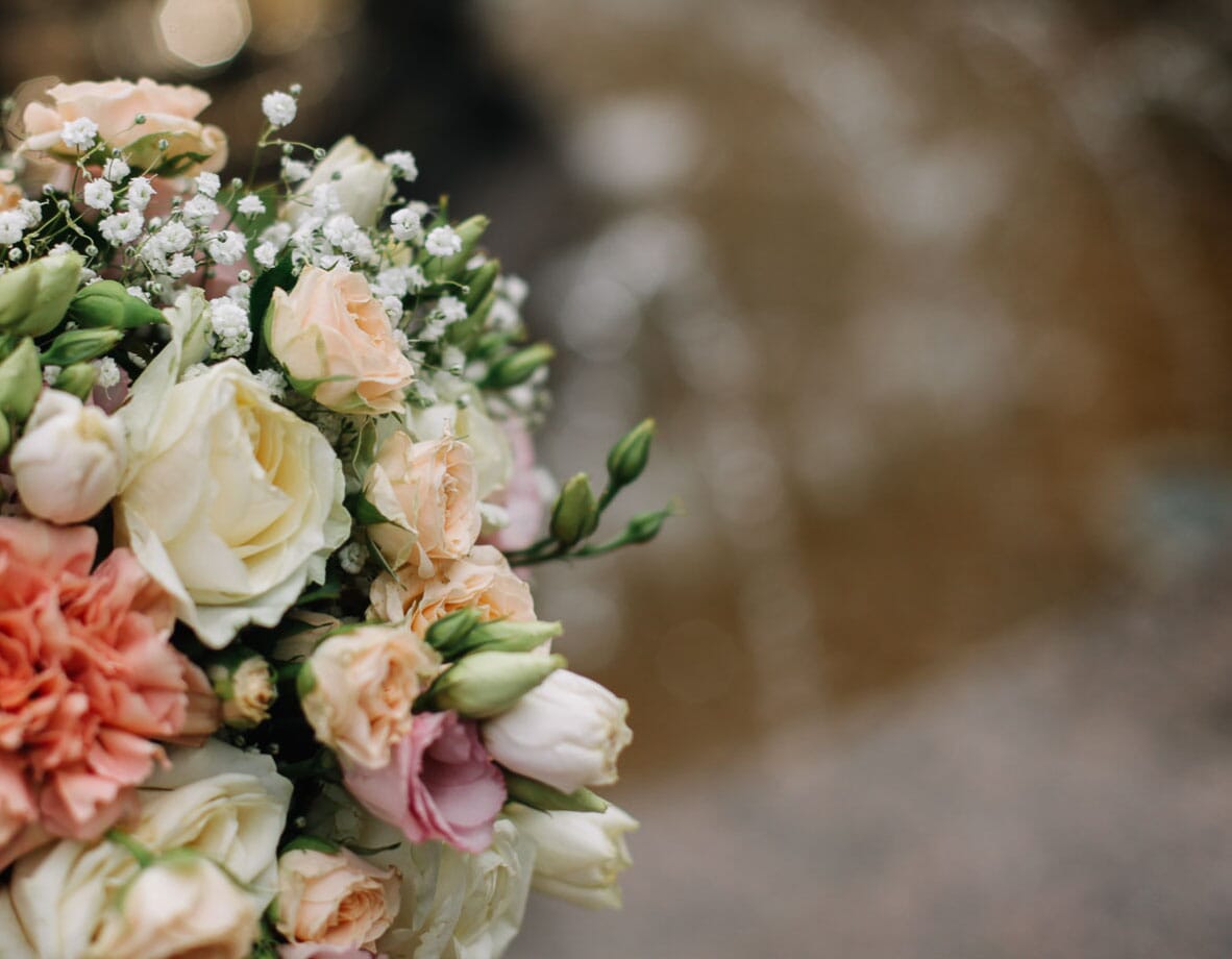DIY bridal bouquet with peach spray roses, white roses, peach carnations, and baby's breath